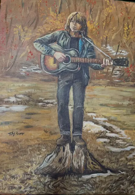 Portrait of Jesse Welles with an acoustic guitar standing in a winter field
